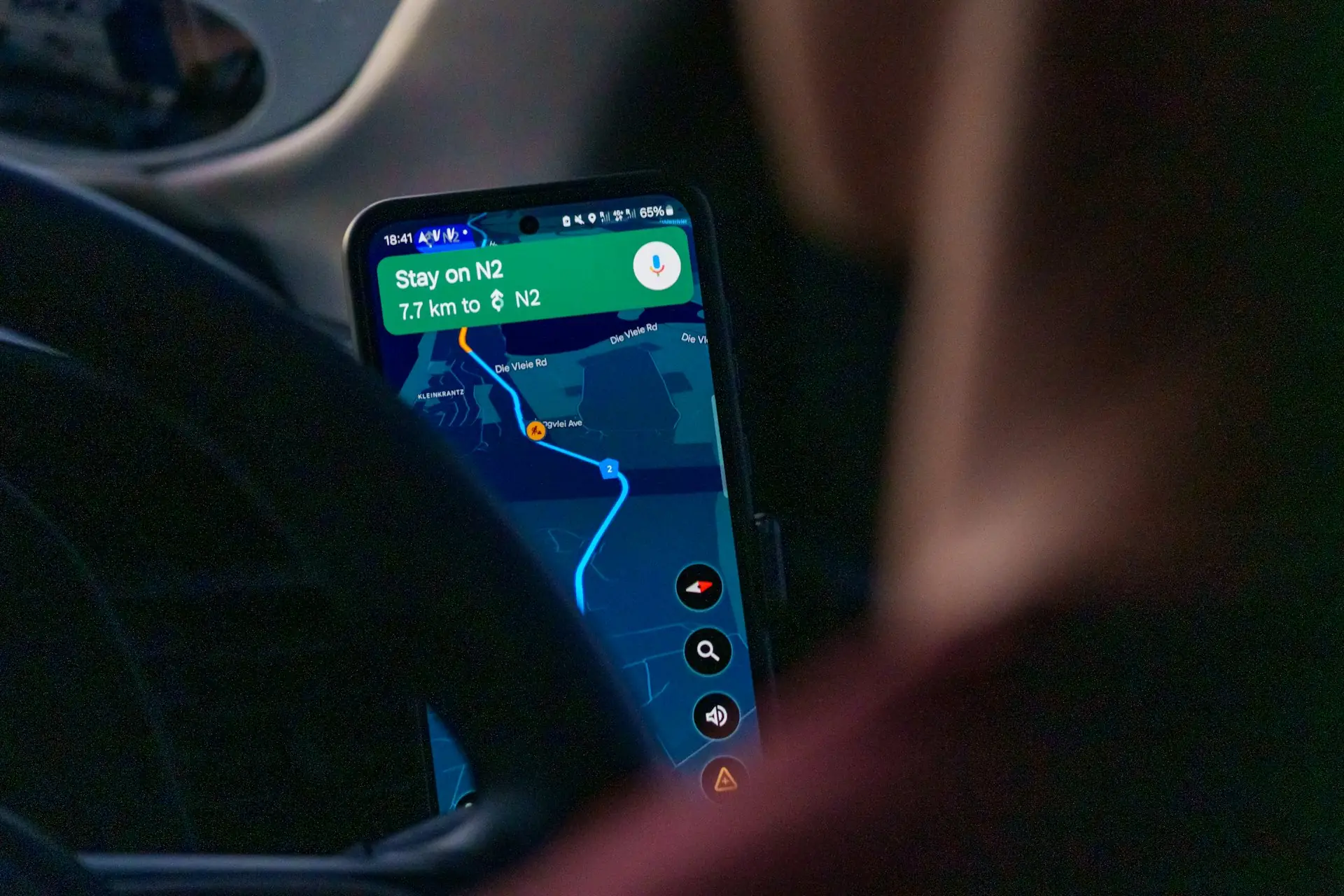 Passenger using a navigation app on a smartphone at night