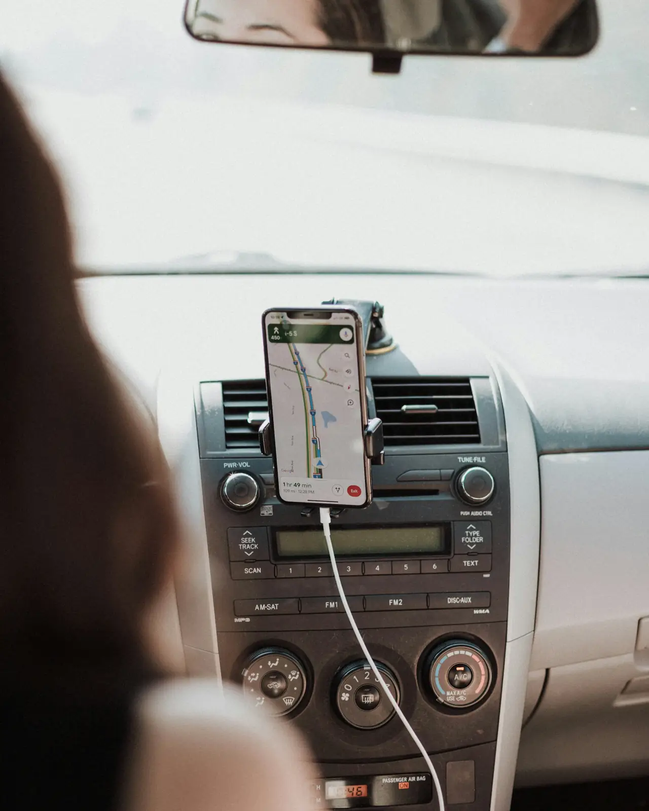 Smartphone showing a map in a dashboard mount inside a car