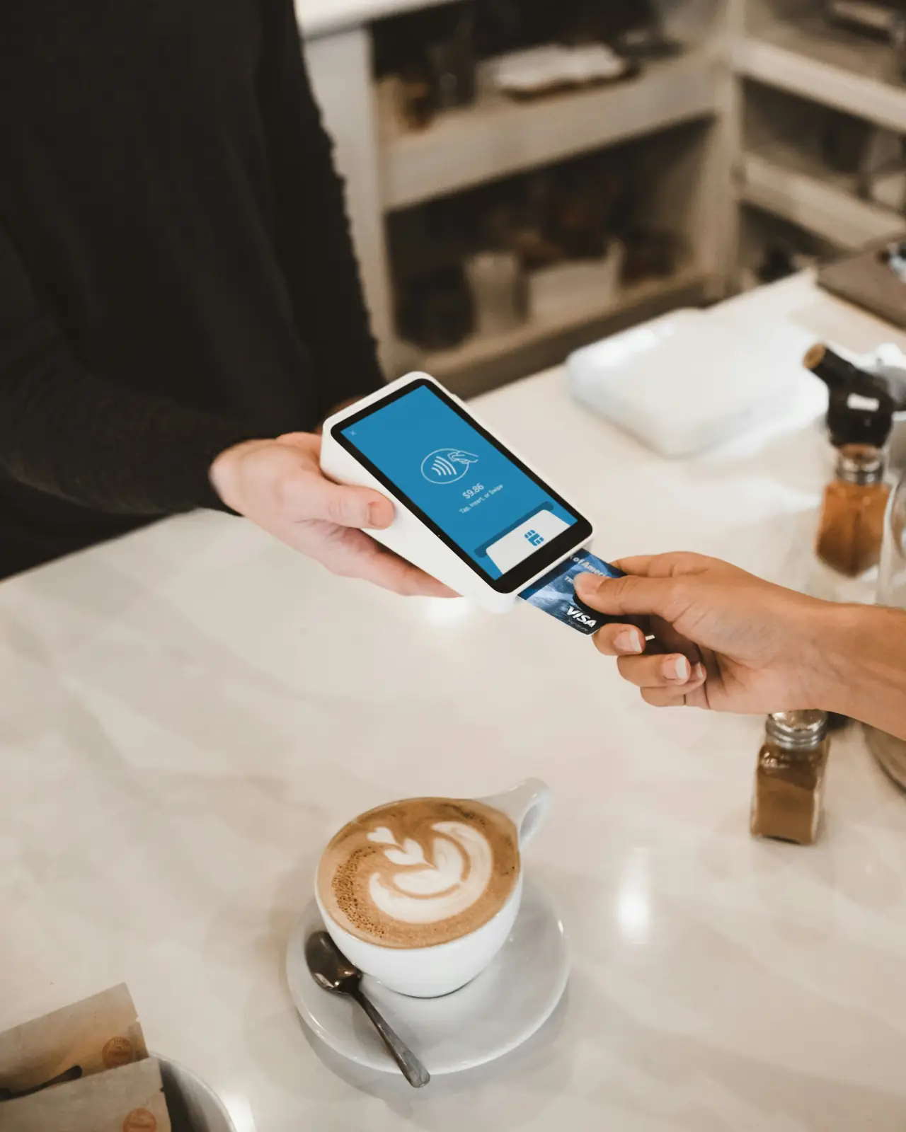 Customer paying contactlessly with a smartphone at a card terminal